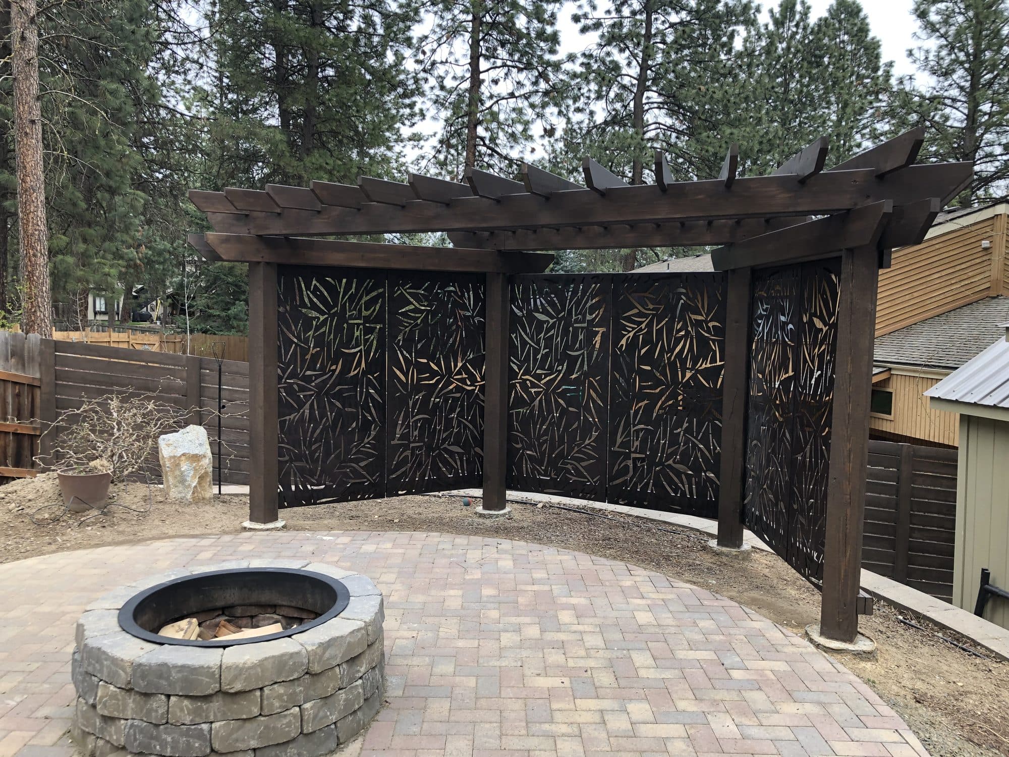 Custom pergola and paver patio with fire pit built by New Life Construction & Remodeling