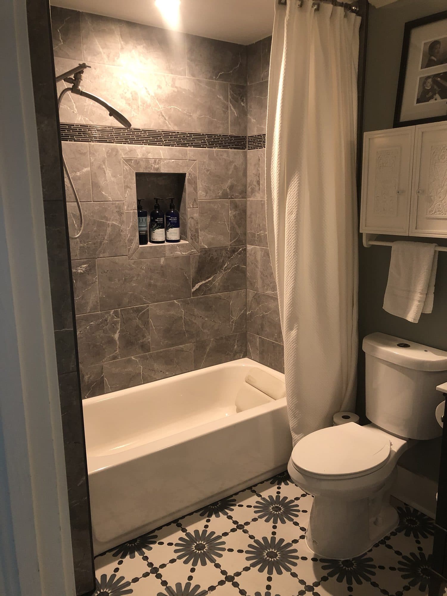 Finished bathroom with marble tile and patterned floor
